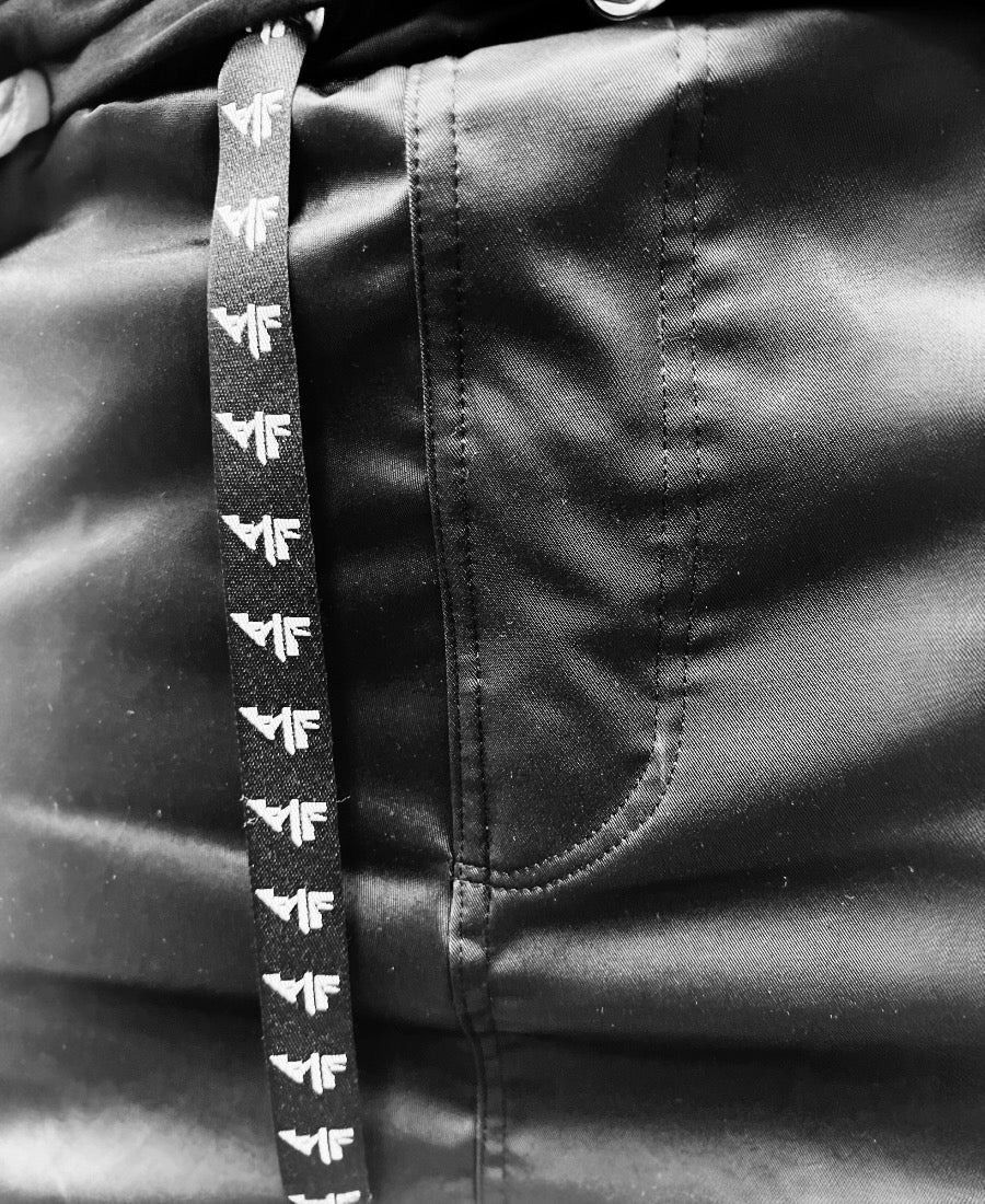 Black trousers made with shiney material and side pockets
