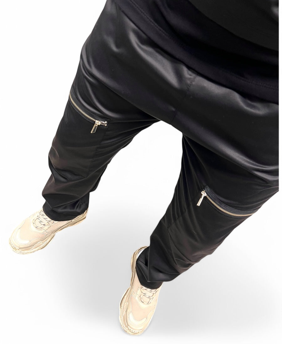 Black trousers made with shiney material, large and with zips