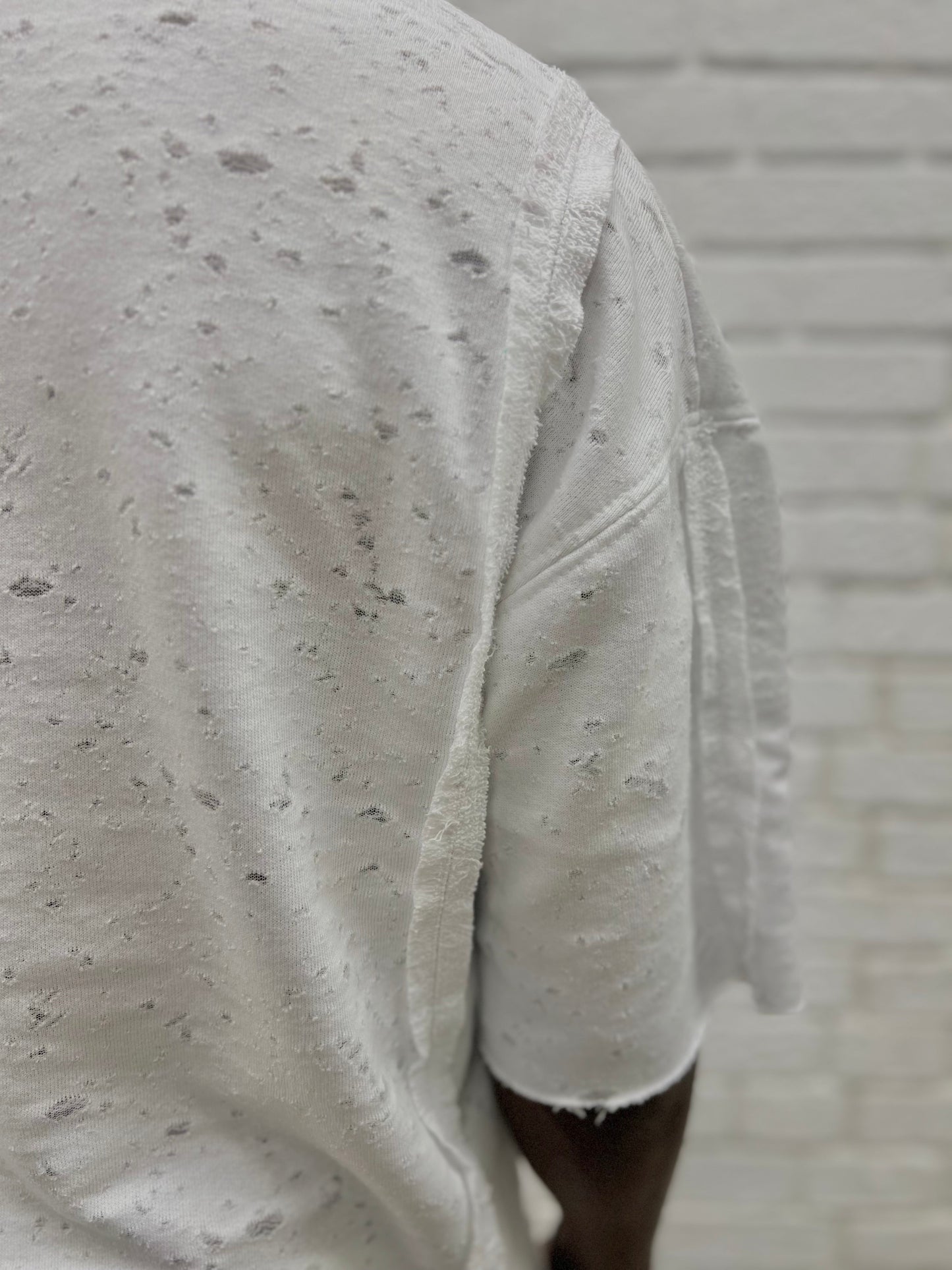 Tricou alb cu material perforat la suprafata ca design