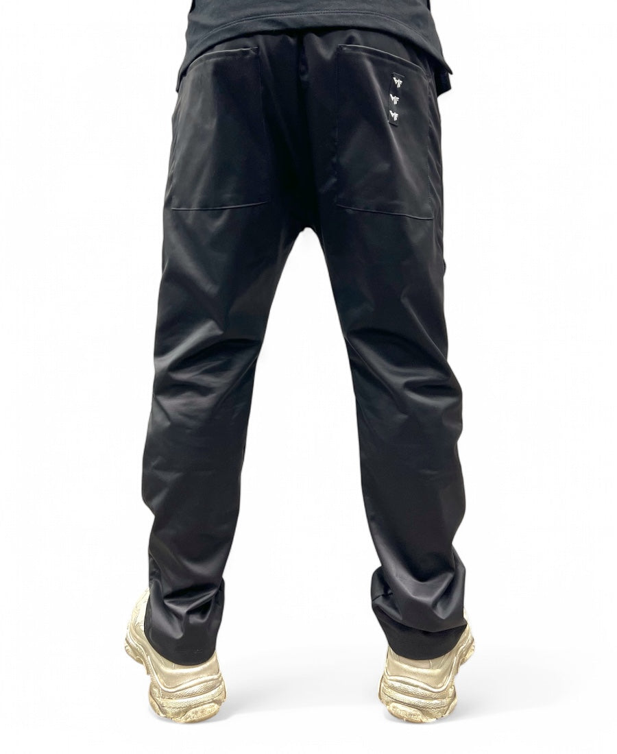 Black trousers made with shiney material, large and with zips
